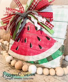 a watermelon painted on wood with burlap and ribbon tied around it