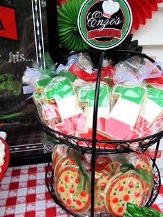 a basket filled with cookies and candy on top of a checkered tablecloth covered table