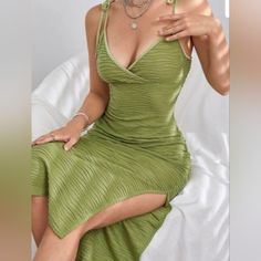 a woman in a green dress sitting on a bed