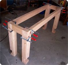 a wooden table with some red handles on the top and two pieces of wood attached to it