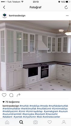 a kitchen with all white cabinets and black counter tops is shown on the phone screen