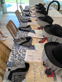 many hats are lined up on the table for an event or celebration to be attended