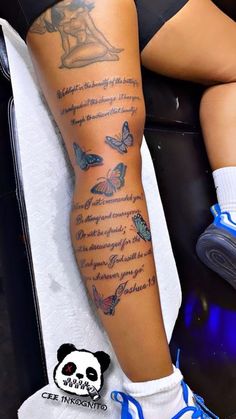 a woman's leg with tattoos and butterflies on it, sitting in a chair