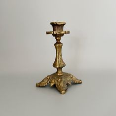 an antique brass candle holder on a gray background