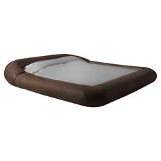 an inflatable dog bed with white sheets and brown trim on the bottom half