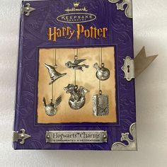 a harry potter ornament hanging from a key chain with the words hogwarts charms on it