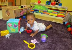 a baby laying on the floor with toys in front of her and other children's playrooms