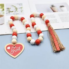 two necklaces with red, white and blue beads are on a table next to an open book