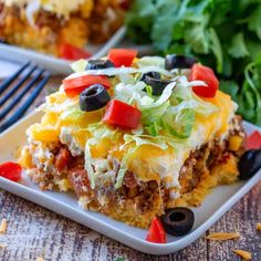 mexican casserole on a plate topped with lettuce and black olives