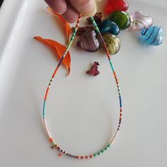 This Glass Seed Bead Necklace consists of White, Turquoise, Red, Light Green, Claret Red, Purple, Orange, Dark Green, Dark Yellow, Glass Seed Beads. Also, the Summer Necklace is perfect for stacking with other necklaces. The seed bead jewelry includes an extension chain of about 1 inch. I used Stainless Steel Jewelry wire, 24K Gold Plated Extension Chain, 24K Gold Plated Lobster Claw. Small Mixed Bead Necklace, Colorful Rainbow Glass Necklace Rainbow Bead Necklace, Seed Bead Necklace, Colorful Necklace Click on the link to see other Multicolored Necklaces, Beaded Chokers. https://www.etsy.com/shop/dkSeedbead?ref=seller-platform-mcnav Summer Rainbow Necklaces With Tiny Beads, Casual Rainbow Beaded Necklace, Seed Bead Necklace Rainbow, Adjustable Rainbow Necklace With Colorful Beads, Mixed Bead Necklace, Vibrant Rainbow Beaded Necklaces, Glass Seed Bead Necklace, Necklaces Beaded, Claret Red