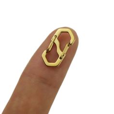 a person's finger with a gold ring in the shape of a letter on it