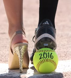 a close up of a person's shoe next to a softball