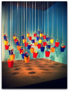 colorful buckets hanging from strings in a room