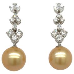 Glamorous dangling earrings. High luster, golden South Sea match pearls, accented with 2.33 carats high brilliance round diamonds. Handcrafted dangling earrings assembles in 18 karats white gold with post and butterfly post. South Sea Pearl: 13mm, high luste, golden tone (AAA quality) Diamond: 2.33 carats round brilliant cut Color: F-G Clarity: VS1-I1 Dimensions: 40mm x 10mm 3mm (approx) Luxury Yellow Gold Victorian Pearl Earrings, South Sea Pearls Earrings, Golden South Sea Pearls, Sea Pearl, Farmhouse Furniture, South Seas, South Sea Pearls, Dangling Earrings, Quality Diamonds