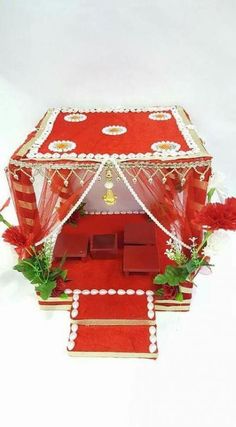 a red and white stage set up for an event with flowers on the floor,