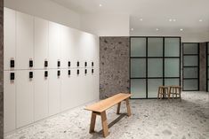 a bench in the middle of a room with several lockers on either side of it