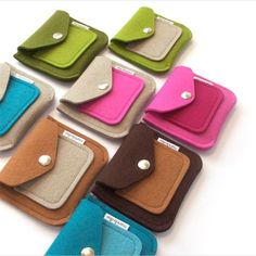 six small wallets are lined up in different colors and sizes, each with a button on the front