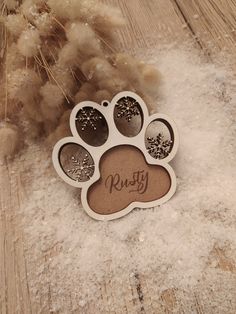 a dog paw ornament with snowflakes on it and the word rusty