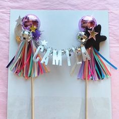 two cake toppers are decorated with balloons and streamers