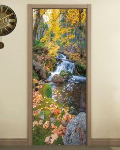 an open door with a waterfall and fall leaves on it