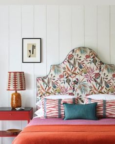 a bedroom with white walls and colorful bedding