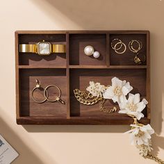 an assortment of jewelry is displayed in a wooden box