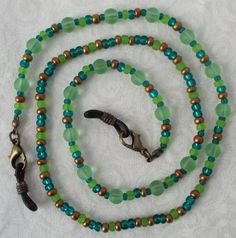 You'll always keep your reading glasses nearby using this green & brown beaded eyeglass chain! 25" in length, made with glass beads, beading cord, metal lobster clasps, and adjustable rubber holders. Lobster clasps make it easy to change the rubber holders, and an extra pair of holders included with every purchase. This green & brown beaded eyeglass chain will arrive in a gift box, ready to give as a present or to keep and store. Back to Beaded Eyeglass Chains Adjustable Green Necklace For Everyday Use, Everyday Adjustable Green Necklace, Everyday Round Beaded Necklaces With Lobster Clasp, Adjustable Colorful Beaded Jewelry For Everyday Use, Adjustable Round Beaded Necklaces For Everyday, Adjustable Beaded Chain Necklace For Everyday, Adjustable Round Bead Glass Necklaces, Adjustable Green Beaded Necklaces With Lobster Clasp, Adjustable Green Czech Glass Beaded Necklaces