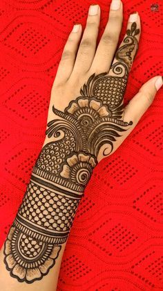 a woman's hand with henna tattoos on her left arm and the top half of