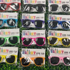 many different colored sunglasses are on display in plastic bags with the words happy birthday written on them