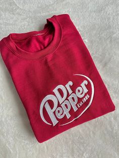 This sweatshirt sports a vintage favorite! High quality with embroidered stitching to last for years.  Material: 50/50 Cotton, Poly Blend T-shirts are Jersey Knit Soft Fabric Fit:  Unisex/ Mens Size Care: Machine wash with like colors. Tumble dry like normal. Want another color shirt or sweatshirt? Message us before purchasing Dr Pepper Clothes, Fire Clothes, Freebies By Mail, Pop Pop Shirts, Happy Birthday Gifts, Dr Pepper, Embroidered Sweatshirt, Thanksgiving Outfit, Soda Pop