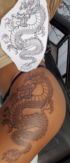 a woman with a dragon tattoo on her back is holding up a piece of paper