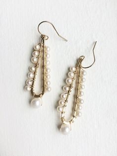 A celebration of pearls in a modern style. A larger pearl dangles from the bottom while smaller pearls line the long teardrop. + Pearls. 14K Gold Filled Ear Wire. 14K Gold Plated Teardrop. + Earrings measure 2.5 inches (6.3 cm) in length. + Earrings take 1 business day to make. + Your jewelry will come in a jewelry box, tied with a ribbon. ➤➤ Have a question about this product, reach out to me here ➙ https://www.etsy.com/conversations/new?with_id=9057464&referring_id=5772224&referring_ty Teardrop Pearl Drop Chandelier Earrings For Party, Pearl Teardrop Dangle Earrings With Pearl Drop, Pearl Drop Teardrop Dangle Earrings, Elegant Teardrop Crown Pearl Drop Earrings, Elegant Chandelier Earrings With Dangling Beads For Celebration, Teardrop Pearl Chain Earrings, Teardrop Pearl Chain Earrings For Anniversary, Elegant Teardrop Pearl Earrings With Dangling Beads, Elegant Teardrop Earrings With Dangling Beads Gift