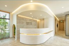 a curved white counter sitting in the middle of a room