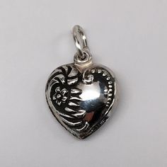 "This antiqued sterling silver, two-sided,repousse Puffy Heart Charm Number 34 features a flower, clefs, foliage, and a row of Victorian beads. Marked, Sterling. Made by Brown County Silver. Vintage and in new, never worn condition. Approximately 30 years old. Small: 5/8\" wide 1/2\" high 1.3 grams approx. Medium: 1/2\" wide 1\" high with jump ring 1.8 grams approx. *Chain not included See more @ https://www.etsy.com/shop/brocosi" Silver Heart Pendant Charms For Mother's Day, Mother's Day Silver Heart Pendant Charm, Valentine's Day Engraved Sterling Silver Charms, Sterling Silver Heart Charms For Valentine's Day, Heart-shaped Sterling Silver Charms For Valentine's Day, Silver Heart Pendant Charms For Valentine's Day, Heart-shaped Sterling Silver Charms, Silver Heart Pendant Charm For Anniversary, Silver Heart Shaped Sterling Silver Charms