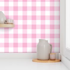 a pink and white checkered wallpaper in a kitchen with two cups on the counter