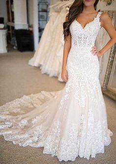 a woman standing in front of a mirror wearing a wedding dress