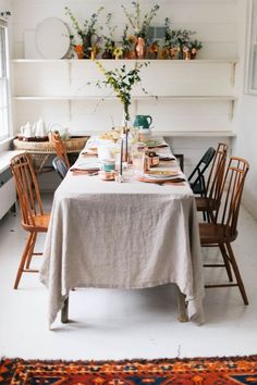 a dining room table is set with plates and cups