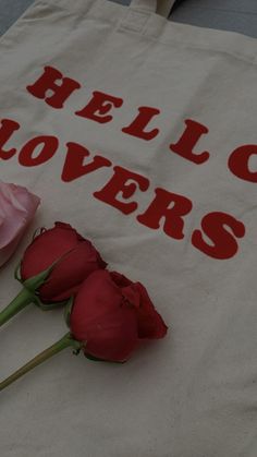 three roses sitting on top of a white bag with the words bello rovers written on it