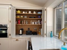 a kitchen with white cabinets and gold pulls on the cupboards is seen in this image