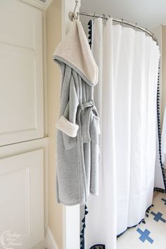 a towel hanging on a shower curtain in a bathroom