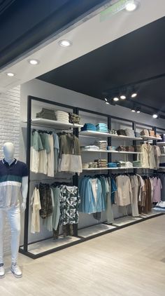 a clothing store with mannequins and shirts on display