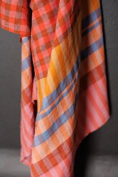 an orange and blue checkered shirt hanging on a wall