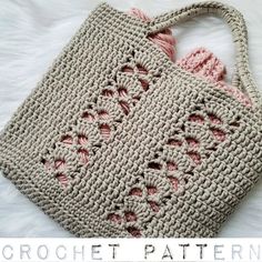 a crocheted bag sitting on top of a white bed next to a pillow