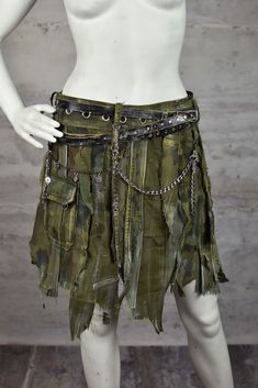 To all wasteland girls: We present to you a skirt crafted from a blend of various recycled fabrics, including those sourced from Polish Army uniforms. The layers of mixed fabrics, including durable denim and cotton blends, in varying shades of green, black, and gray, tattered edges, and the addition of chains and leather straps are all combined to evoke the essence of post-apocalyptic times.  Choose to wear this skirt on your hips or waist, and we will tailor it to fit your needs, ensuring you l Rock Style Halloween Festival Skirt, Skirt With Chains, Post Apocalyptic Outfit, Distressed Clothing, Army Outfit, Larp Costume, Military Girl, Army Uniform, Fabric Strips