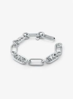 Available in three high-shine platings, this brass bracelet strikes the perfect balance between impactful and wearable. It showcases interlocking chain links interspersed with our “MK” initials. It’s designed to be worn with the matching necklace, but looks just as cool on its own. Metal Chain Bracelet With Rectangular Links And Polished Finish, Polished Oval Link Metal Chain Bracelet, Modern Michael Kors Jewelry For Gift, Michael Kors Modern Jewelry For Gifts, Classic Silver Michael Kors Jewelry, Luxury Silver Michael Kors Jewelry, Michael Kors Luxury Silver Jewelry, Michael Kors Classic Silver Jewelry, Apply Perfume