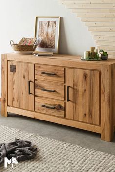 a wooden sideboard sitting on top of a rug next to a stair case in a living room