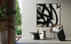 an abstract painting hangs on the wall next to a chair and table in a modern living room