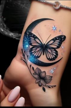 a woman's hand with a butterfly and flower tattoo on the side of her arm