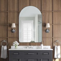 a bathroom with a mirror, sink and towel rack on the wall in front of it