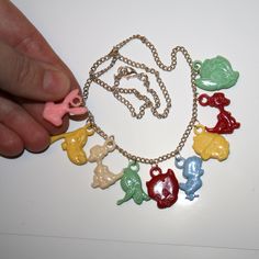 "Cartoon Celluloid Charm Necklace Necklace is made with a mix of vintage celluloid charms Each necklace has 9 charms. These are very old/antique celluloid charms from the 60s. These are light! All charms are lightweight so even though these are large they are not heavy Necklaces measure 18\" long. Charms are RANDOM, but all necklaces have at least one of each character and at least one of each color shown." Vintage Necklaces With Vintage Charm For Festival, Vintage Collectible Charm Necklaces, Vintage Handmade Multicolor Charm Necklace, Vintage Multicolor Handmade Charm Necklace, Vintage Handmade Multicolor Charm Bracelet, Whimsical Vintage Charm Jewelry, Vintage Charm Long Costume Necklace, Vintage Multicolor Charm Necklaces, Vintage Enamel Necklaces With Lobster Clasp